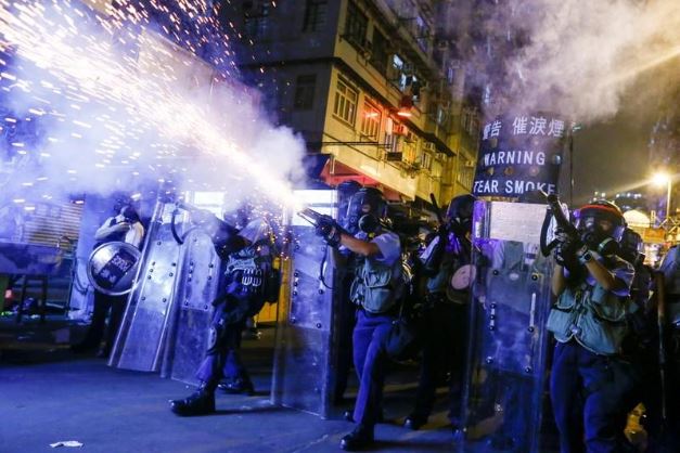 شرطة هونج كونج تطلق قنابل الغاز المسيل للدموع ضد محتجين أثناء اشتباك في منطقة شام شوي في هونج كونج يوم الأربعاء. تصوير: تايرون سيو - رويترز.